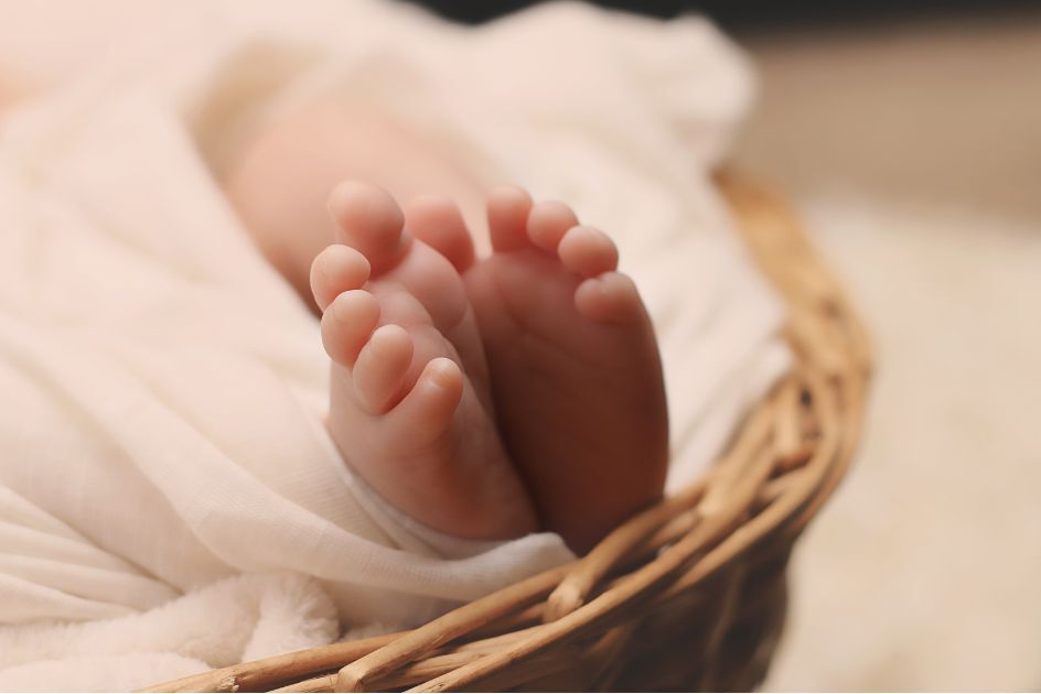Baby feet sticking out of a whicker basket